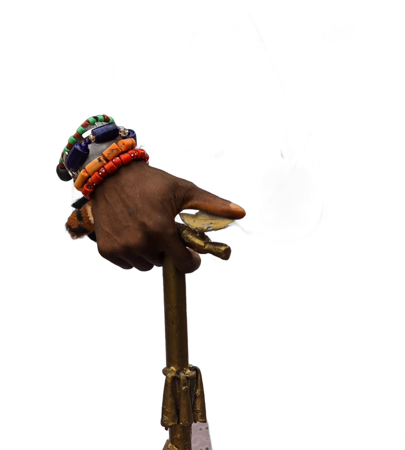 Mano con pulseras de cuentas sosteniendo un atributo ritual